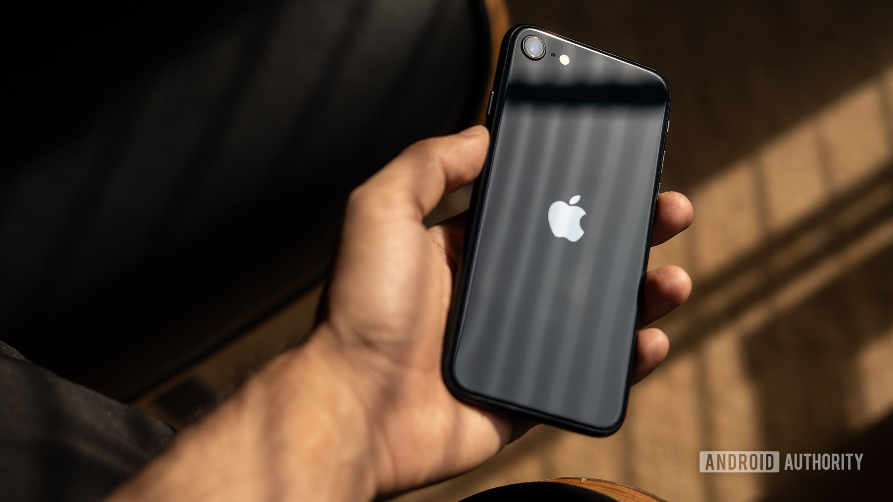 iPhone SE 2022 meninjau opini kedua yang menunjukkan bagian belakang ponsel di tangan