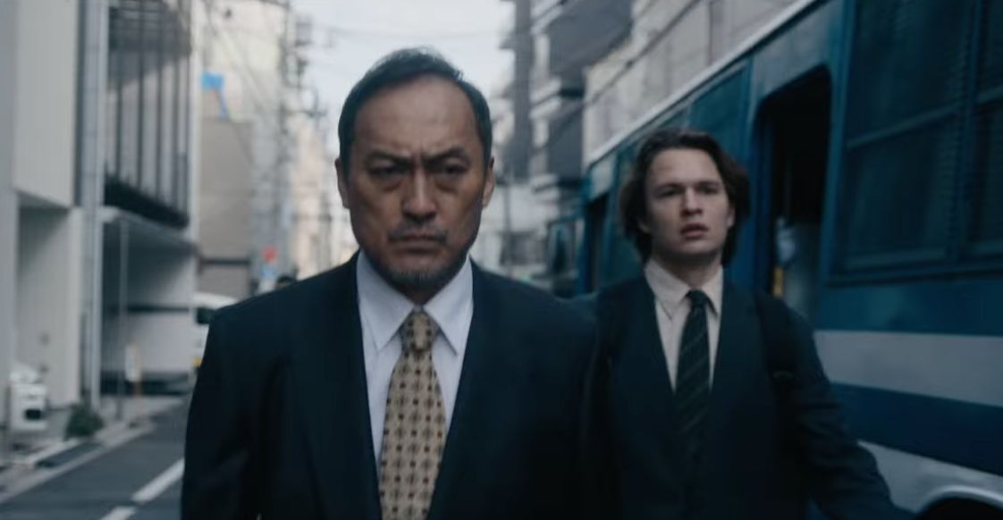 Two characters from Tokyo Vice walk down a street.