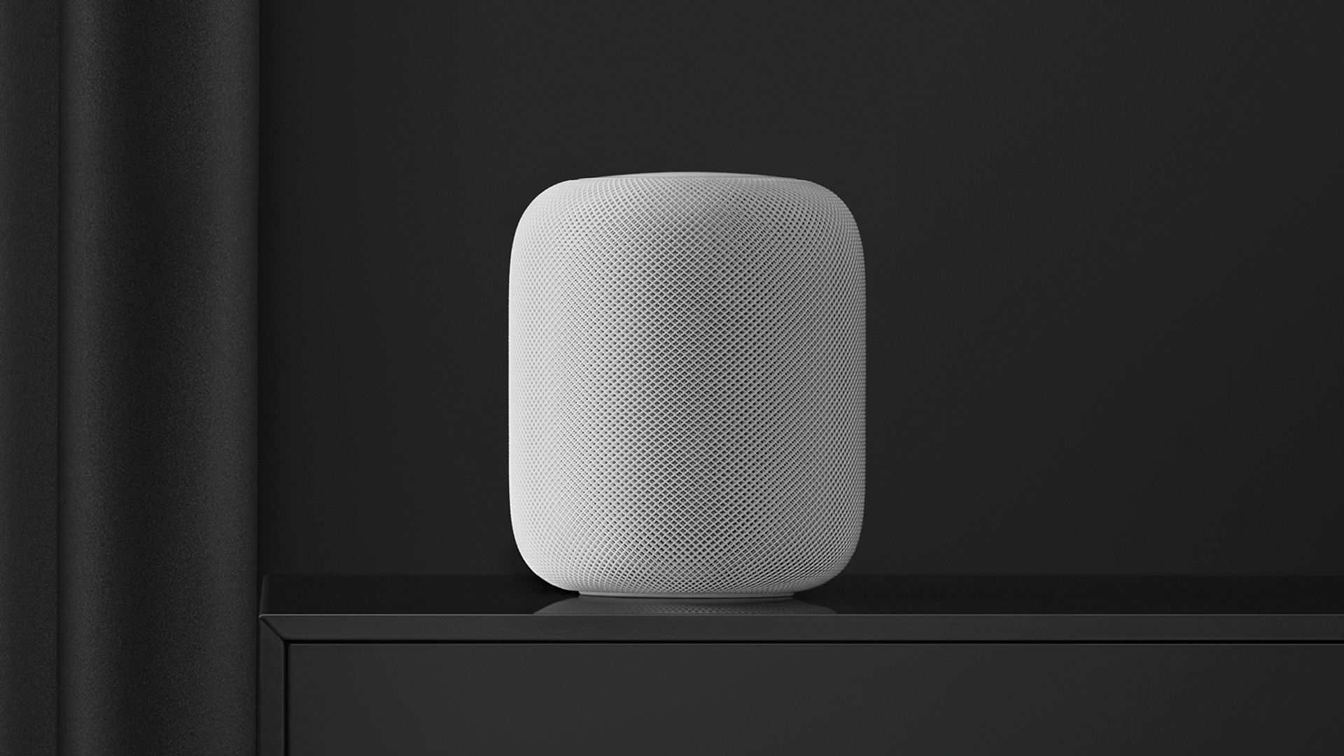 A white 2018 HomePod in a black room