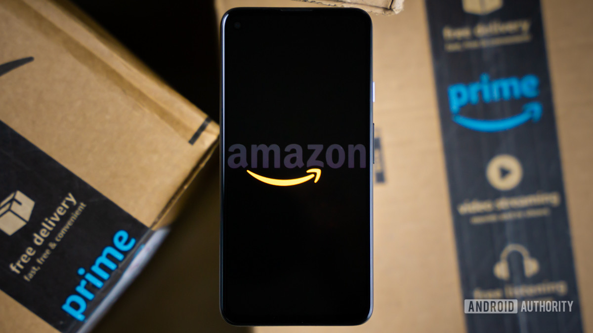 Amazon logo on phone next to boxes stock photo 1