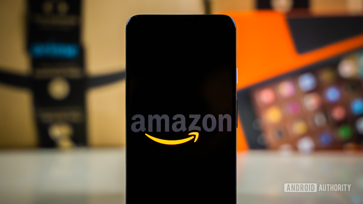 Amazon logo on phone next to boxes stock photo 10
