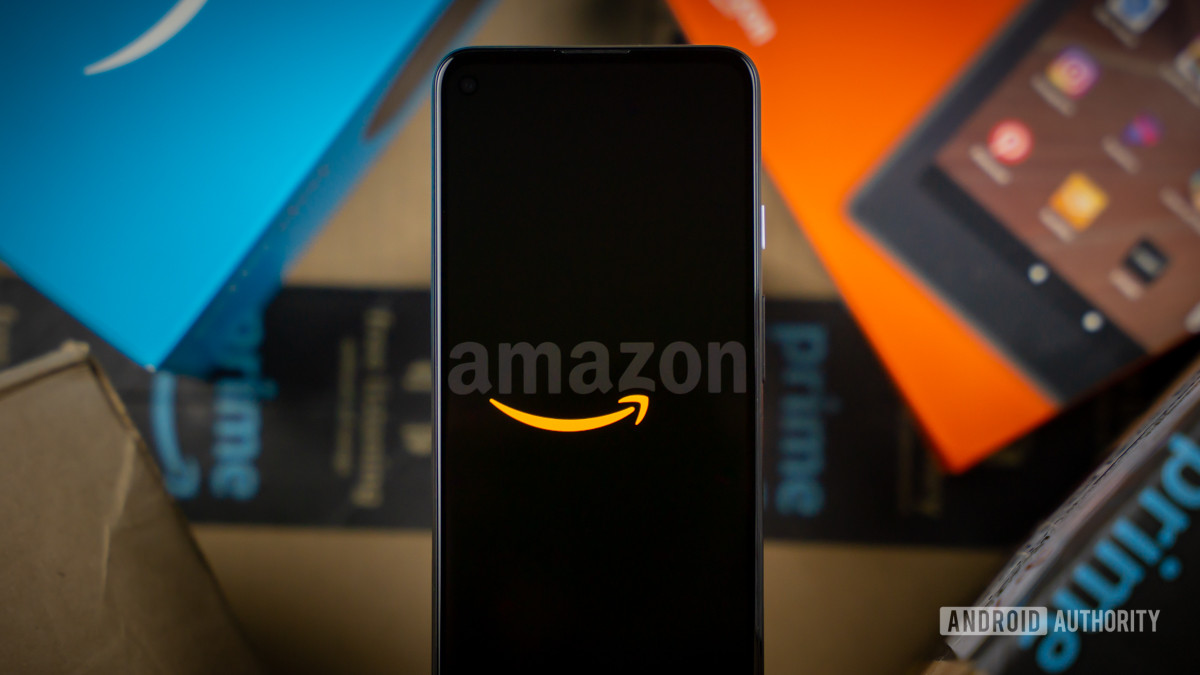Amazon logo on phone next to boxes stock photo 11