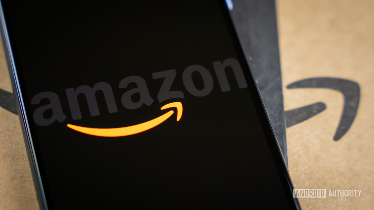 Amazon logo on phone next to boxes stock photo 14