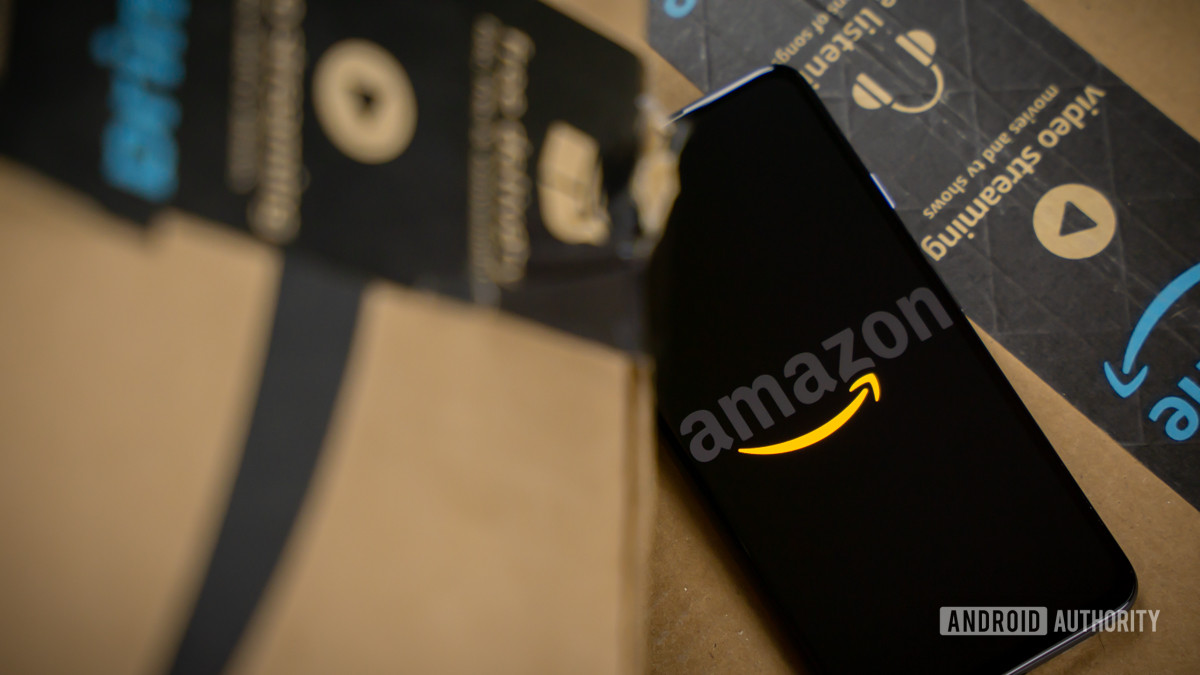 Amazon logo on phone next to boxes stock photo 16