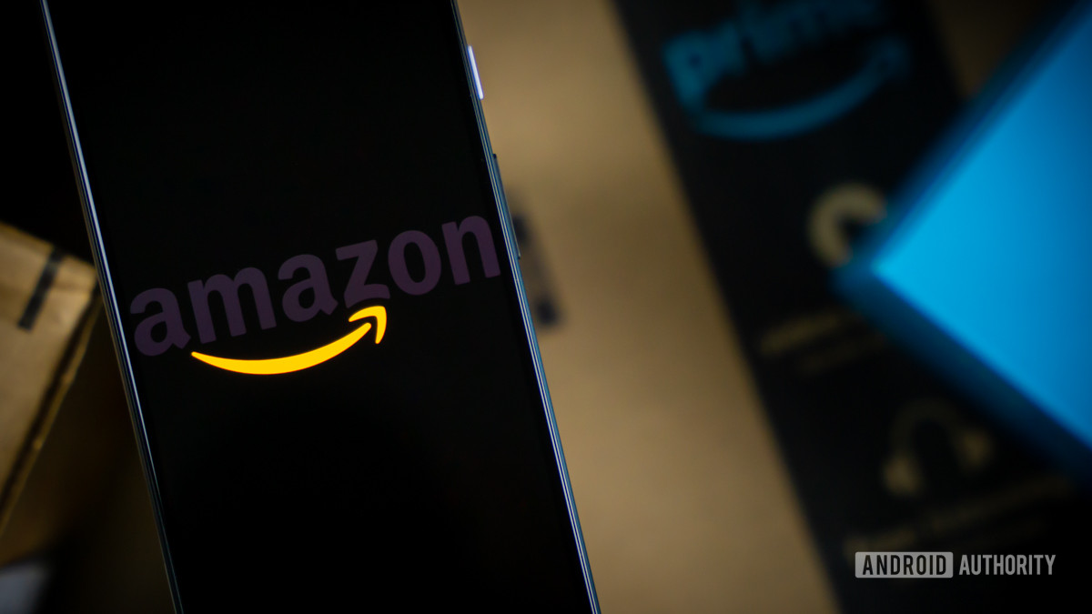 Amazon logo on phone next to boxes stock photo 2