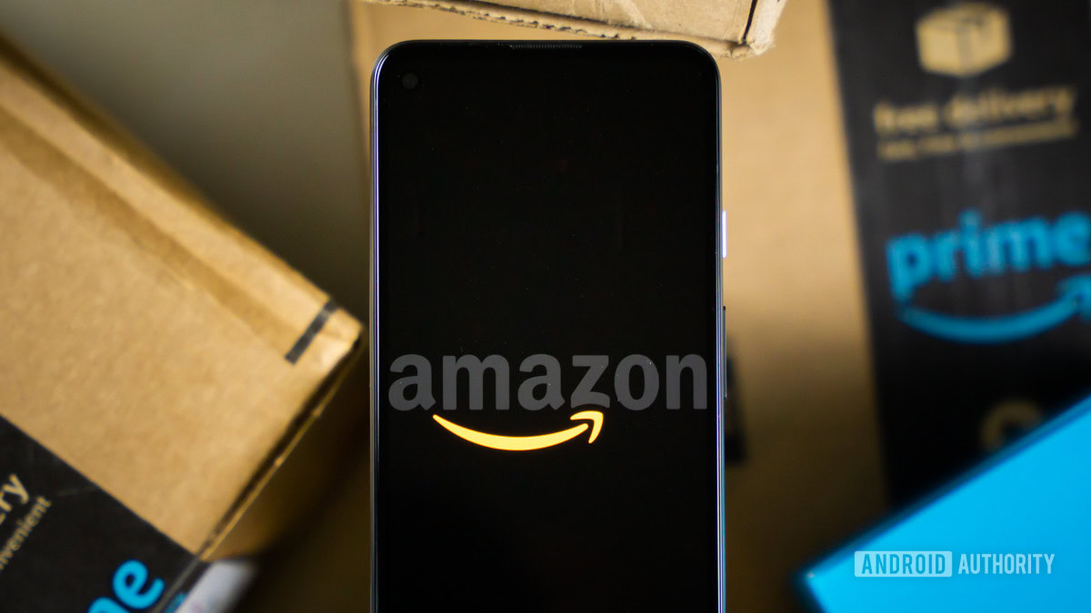 Amazon logo on phone next to boxes stock photo 3