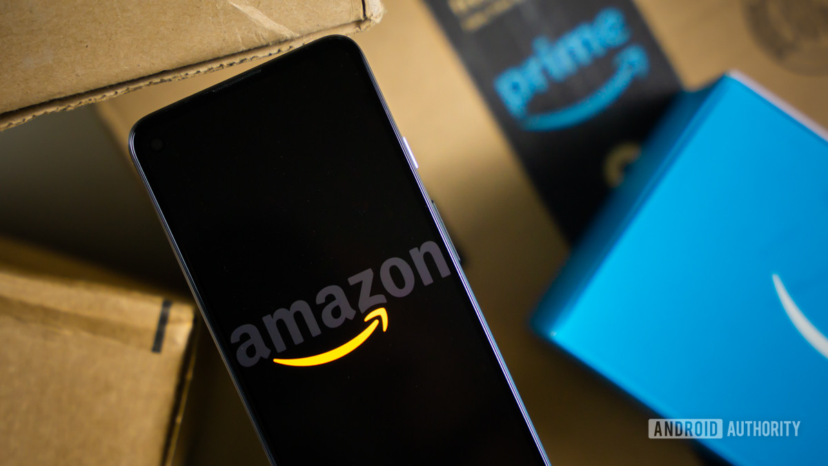 Amazon logo on phone next to boxes stock photo 4