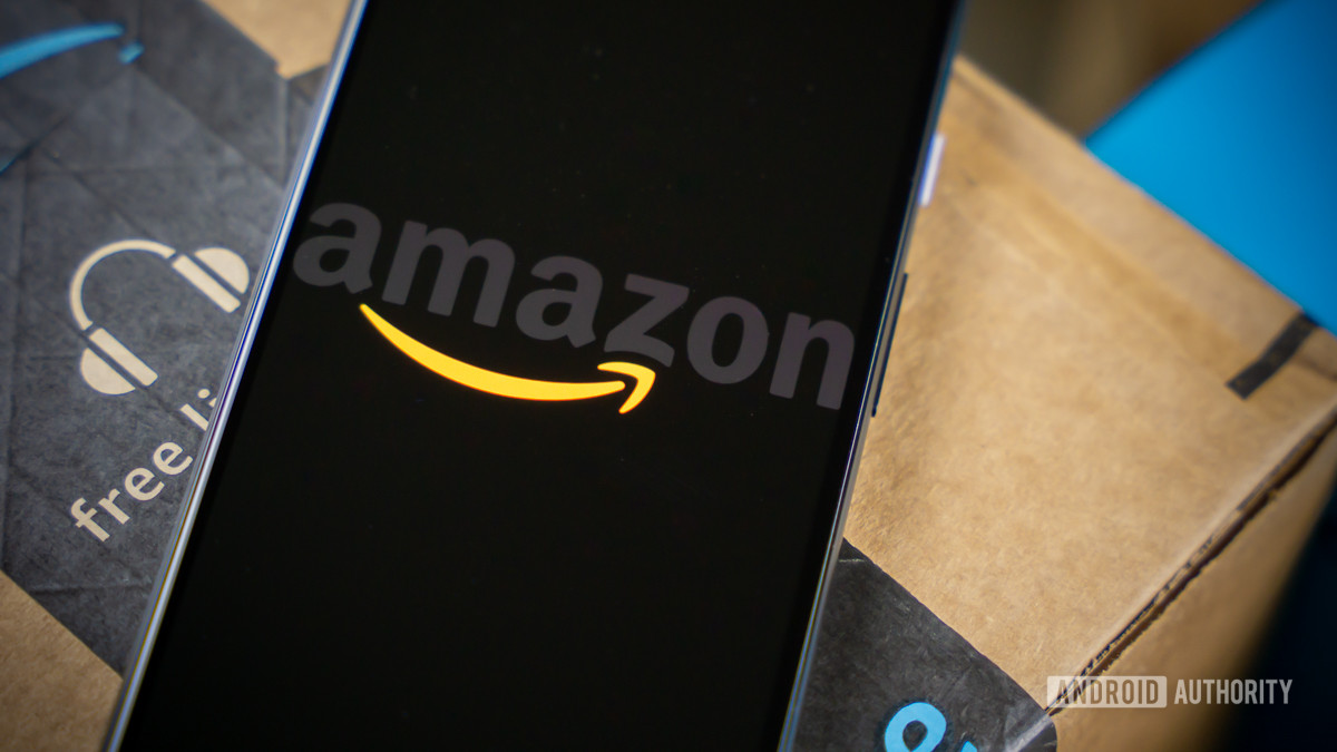Amazon logo on phone next to boxes stock photo 6