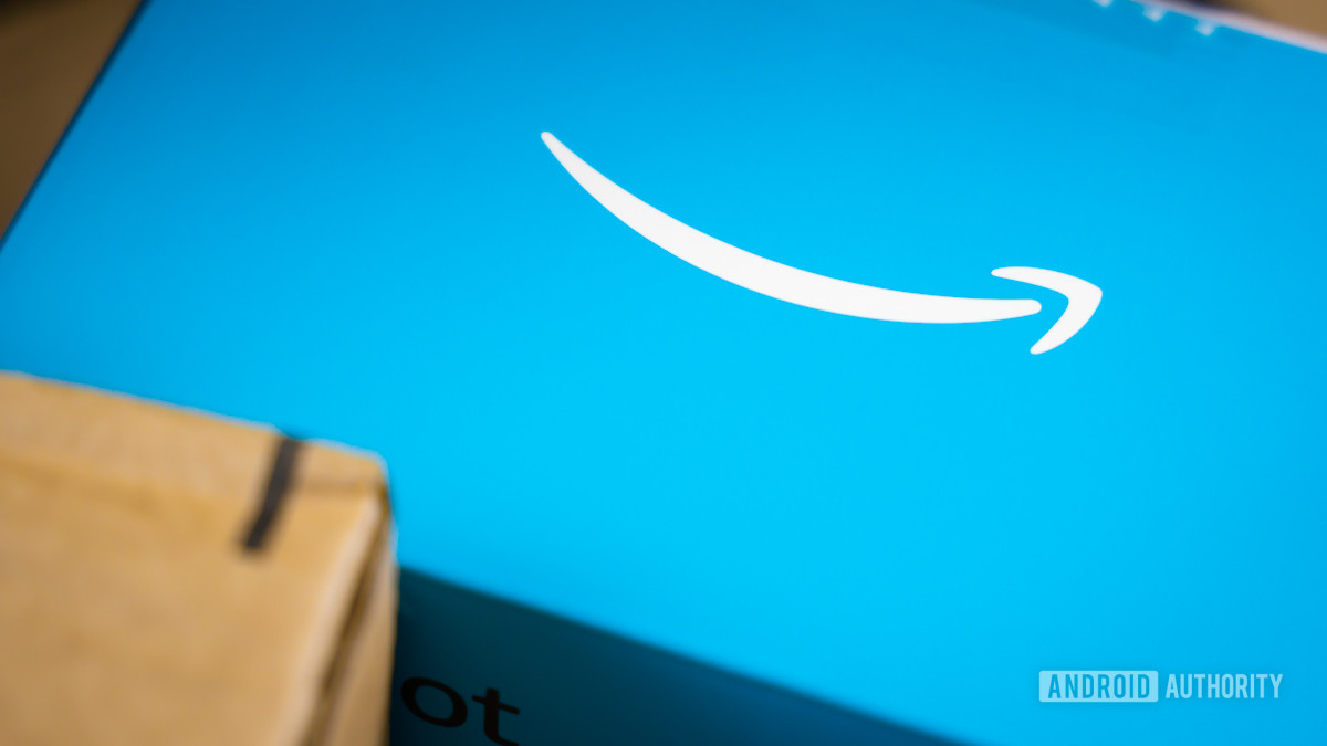 Amazon logo on phone next to boxes stock photo 7