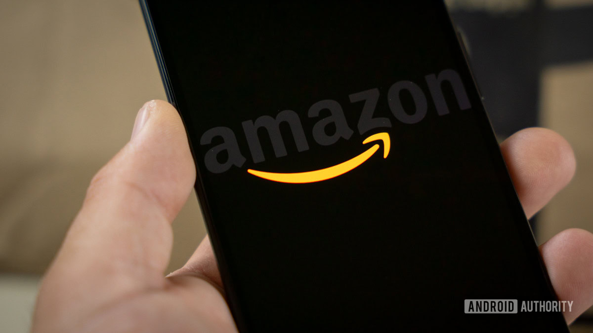 Amazon logo on phone next to boxes stock photo 8