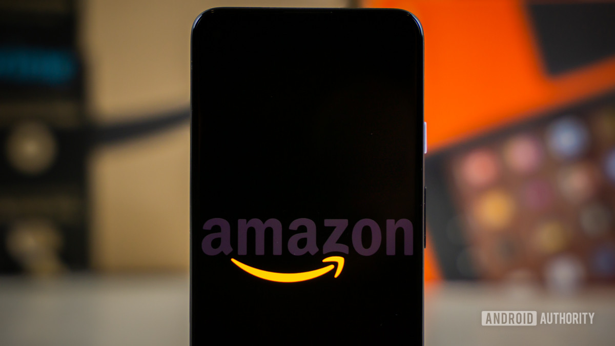 Amazon logo on phone next to boxes stock photo 9