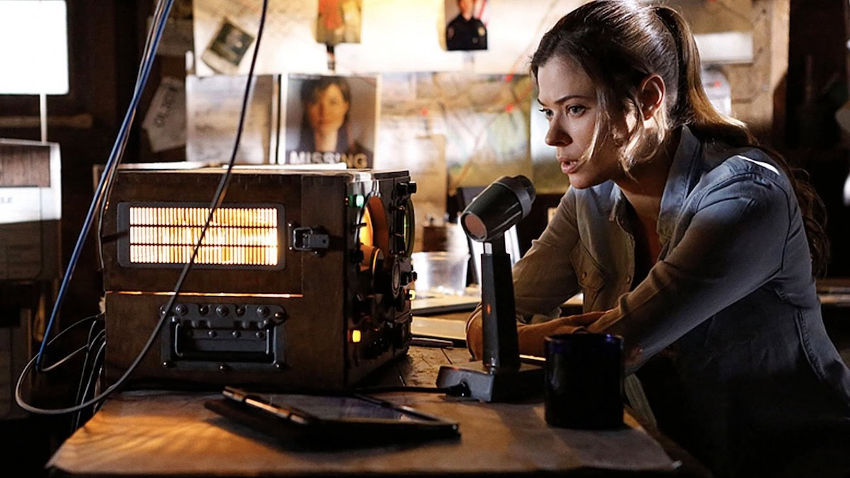 A woman sits at a radio in Frequency