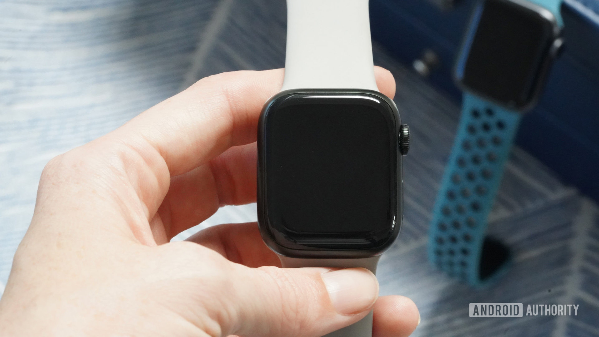 A user holds an Apple Watch Series 7 in hand.