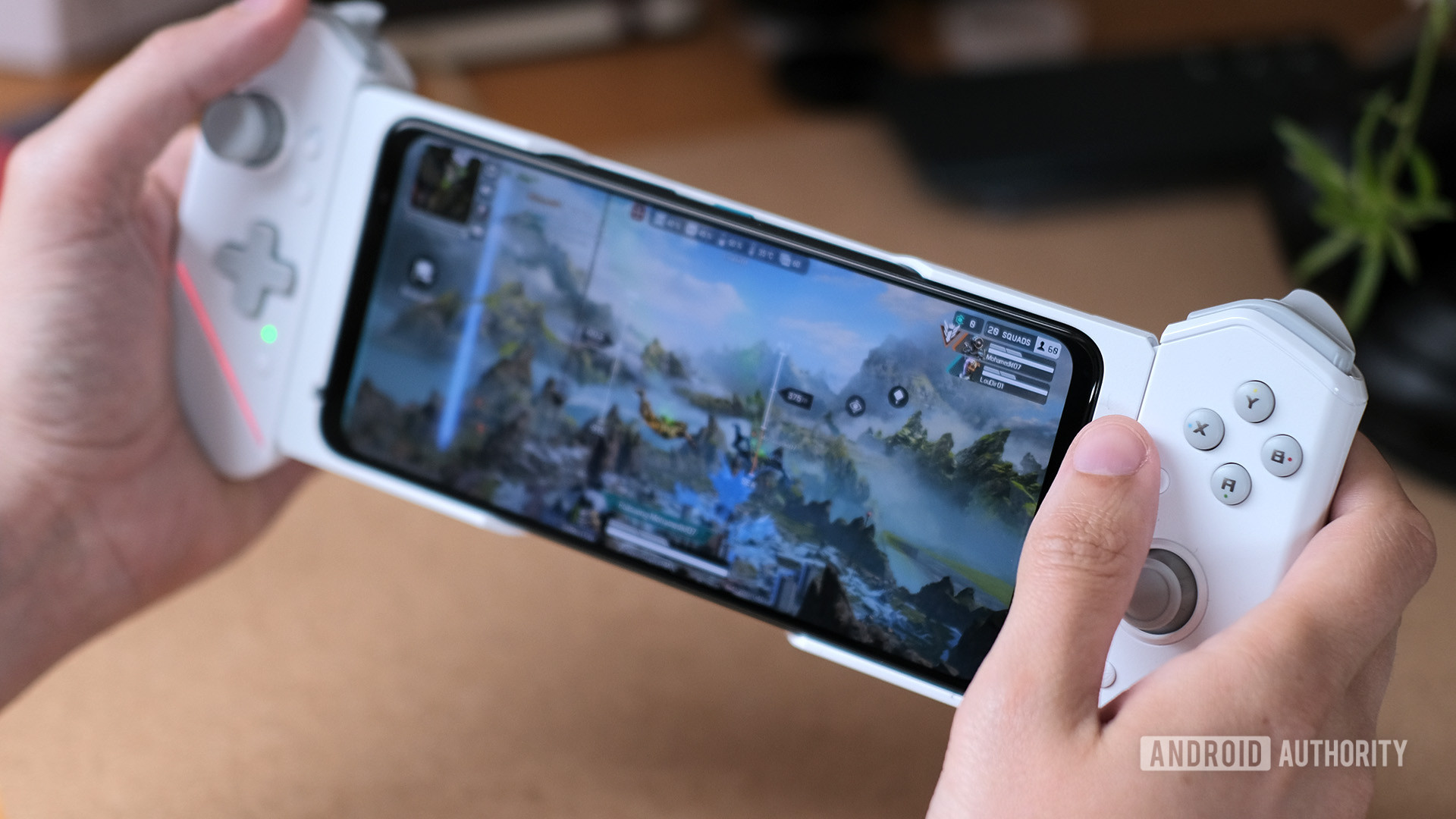 Two hands holding a white ASUS Rog Phone 6 Pro with controllers attached to each side of it.