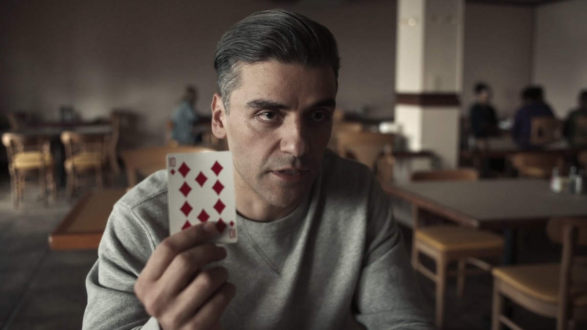 Oscar Isaac holds up a ten of diamonds in The Card Counter