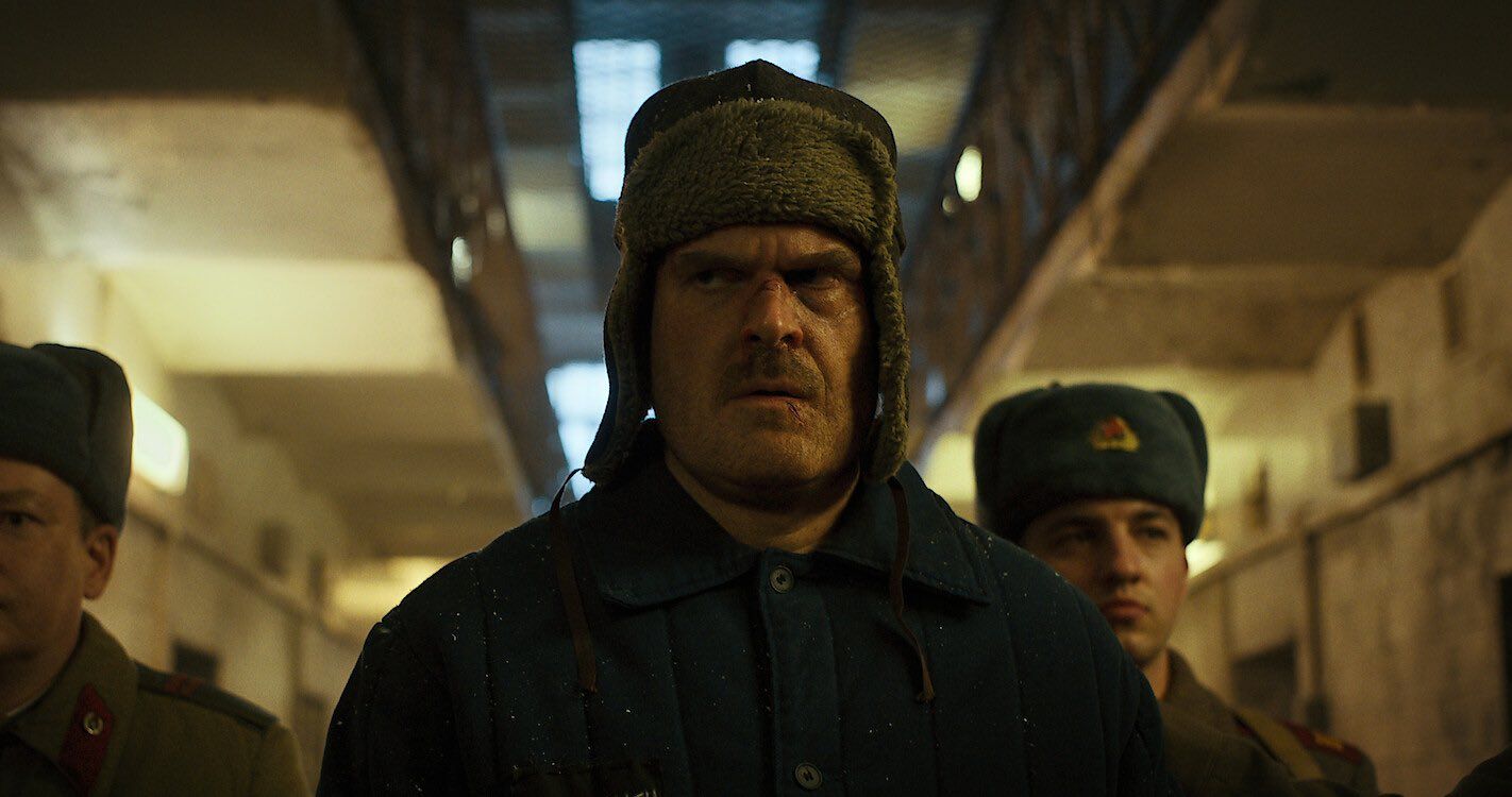 Hopper is escorted by two prison guards in stranger things season 4