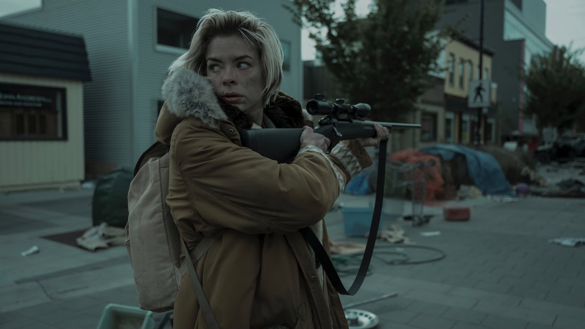 Jaime King aims a rifle while looking behind her on a deserted street in Black Summer - best shows like resident evil on netflix