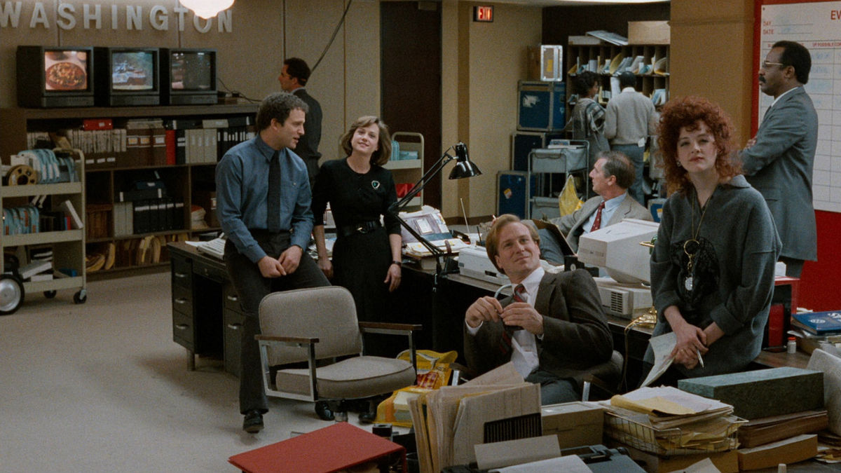 Journalists sit together at a TV news station in Broadcast News - best movies leaving HBO Max