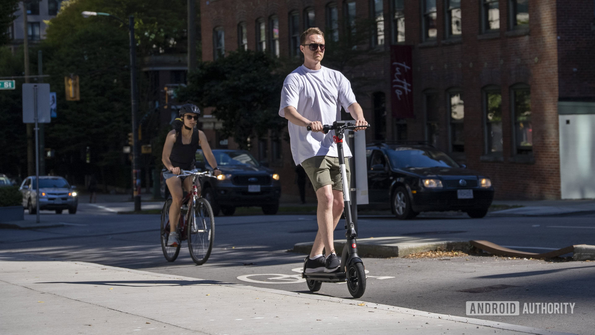 ridign e-scooter beside cyclist in traffic