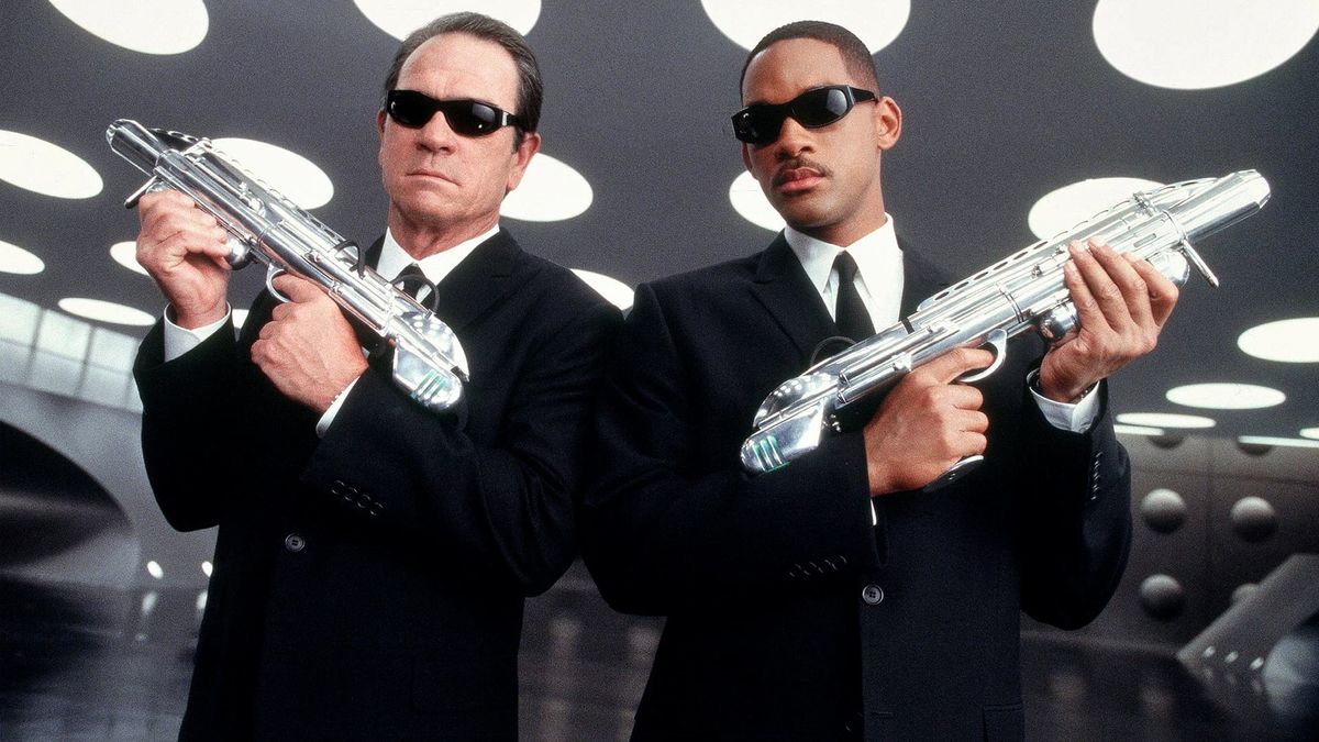 Will Smith and Tommy Lee Jones holding sci-fi weapons in Men in Black - netflix funny movies