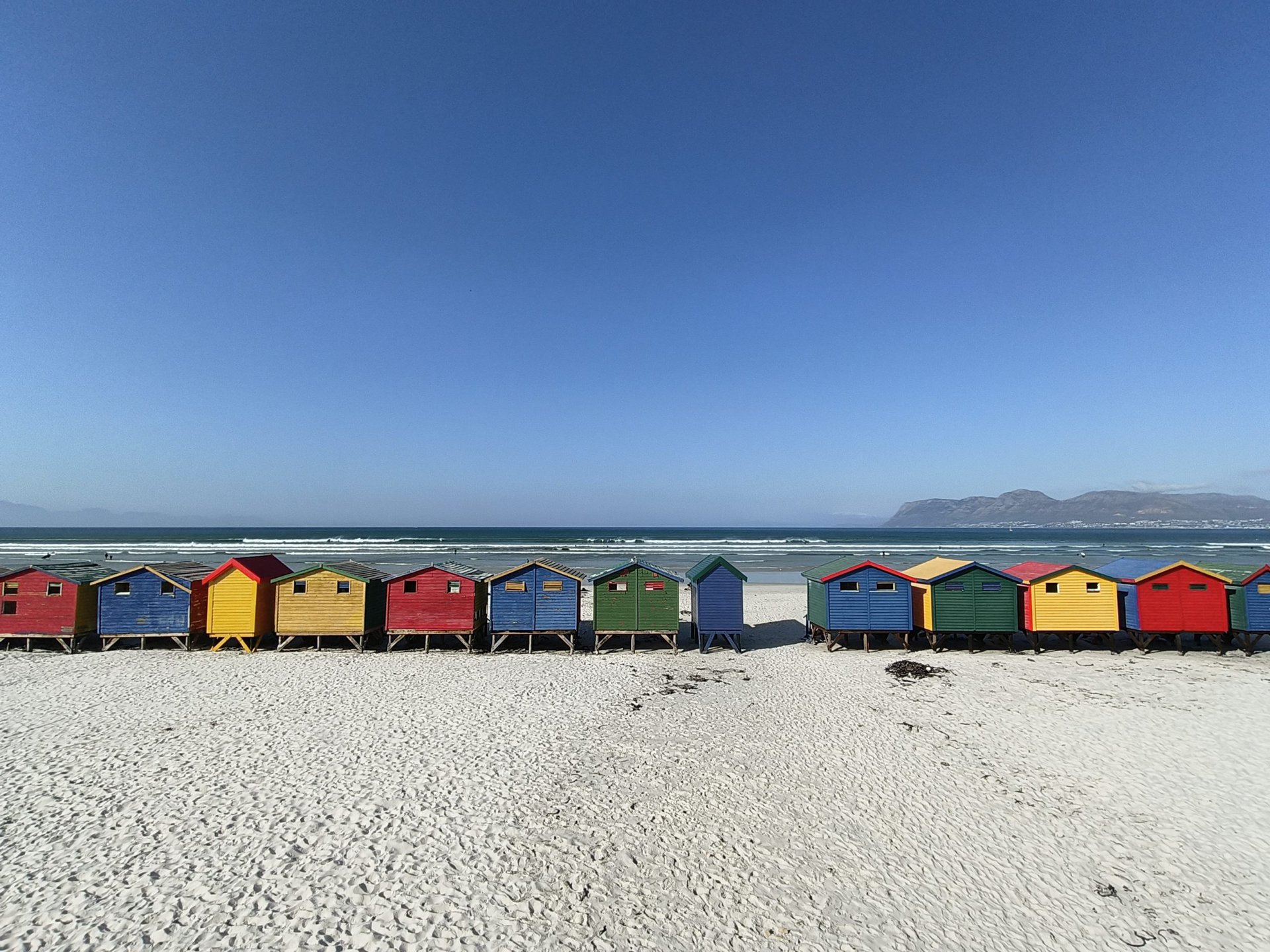 OPPO Reno 8 Pro ultrawide shot of colorful beach huts on a sandy beach.