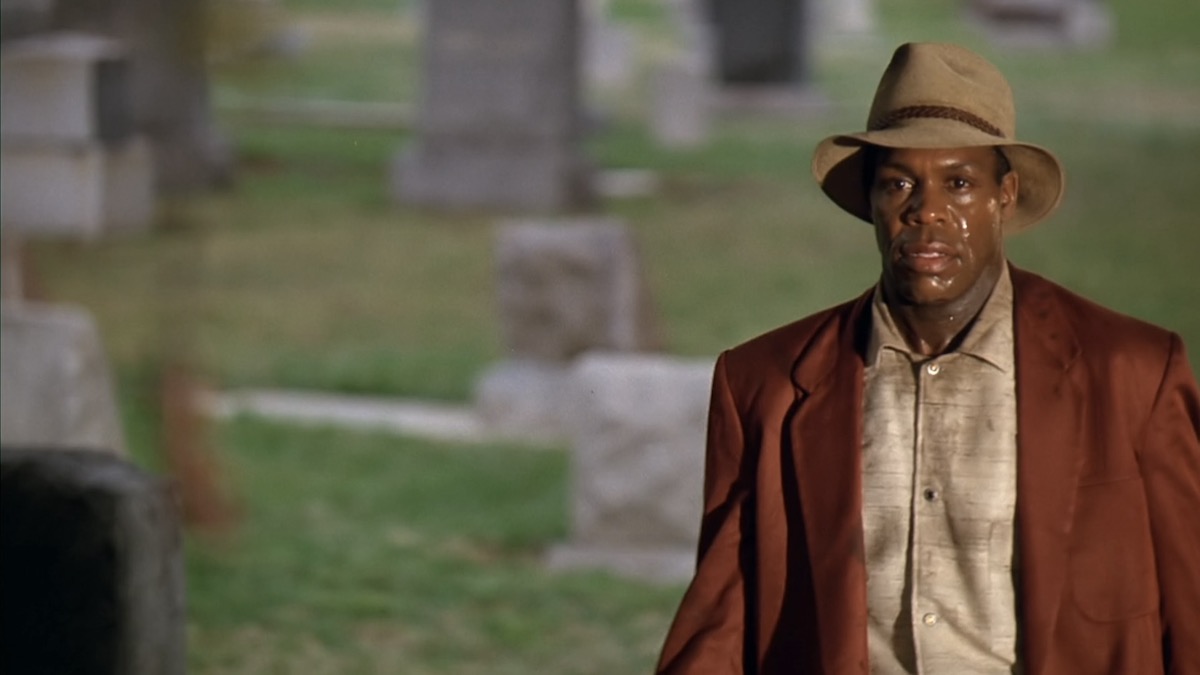 Danny Glover stands in a cemetery, sweating, in Predator 2 - heat wave movies