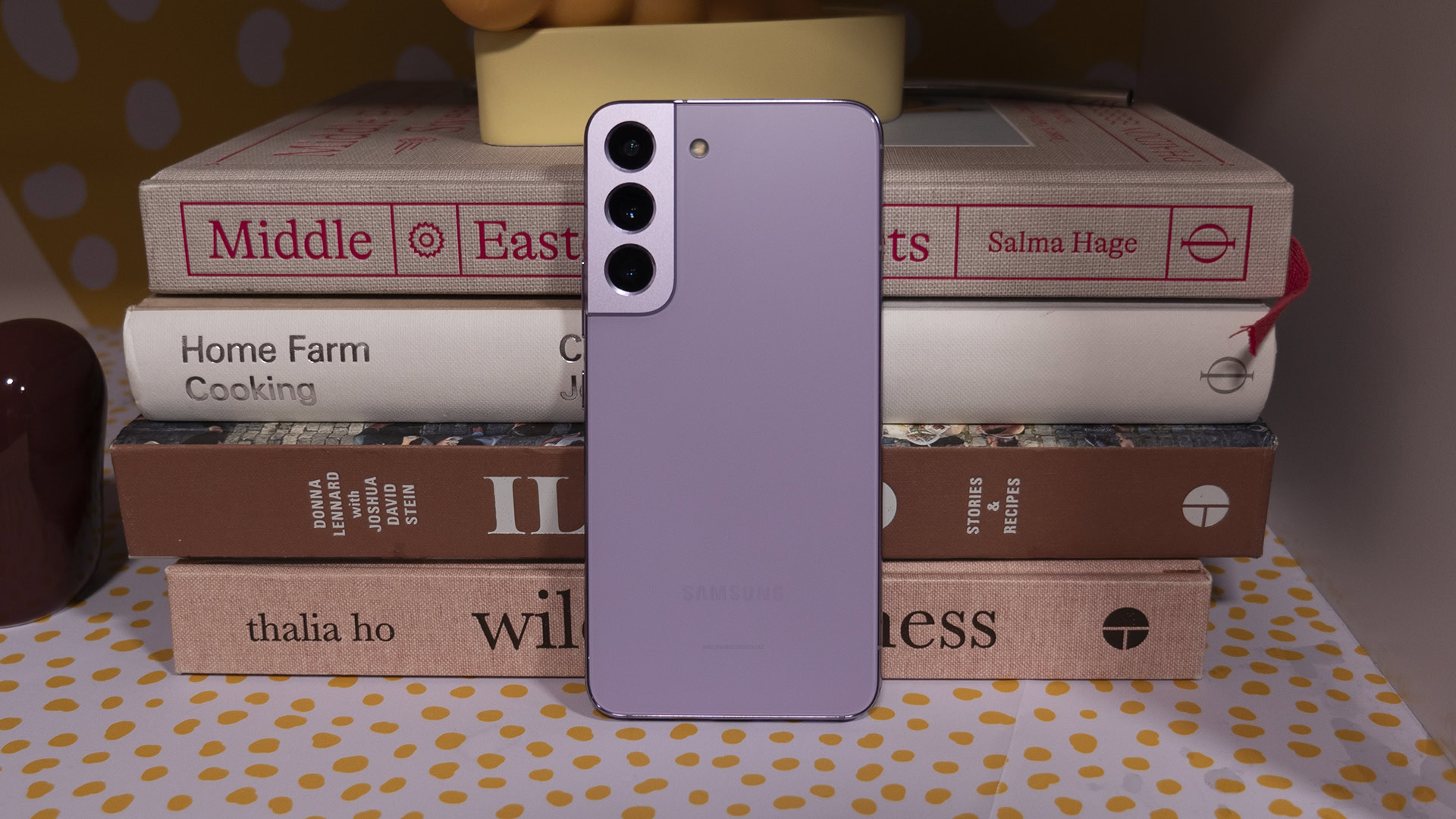 Samsung Galaxy S22 Bora Purple Leaning Against Books