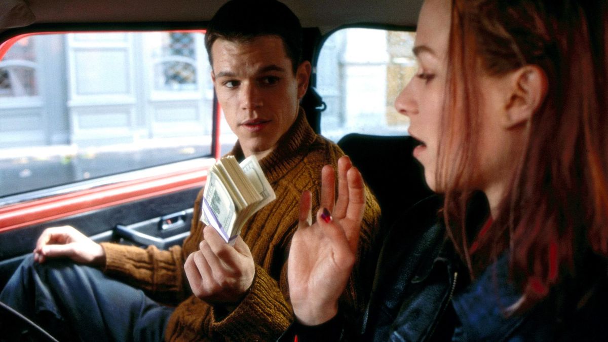 Matt Damon handing cash to Franka Potente in a car in The Bourne Identity - movies like the gray man