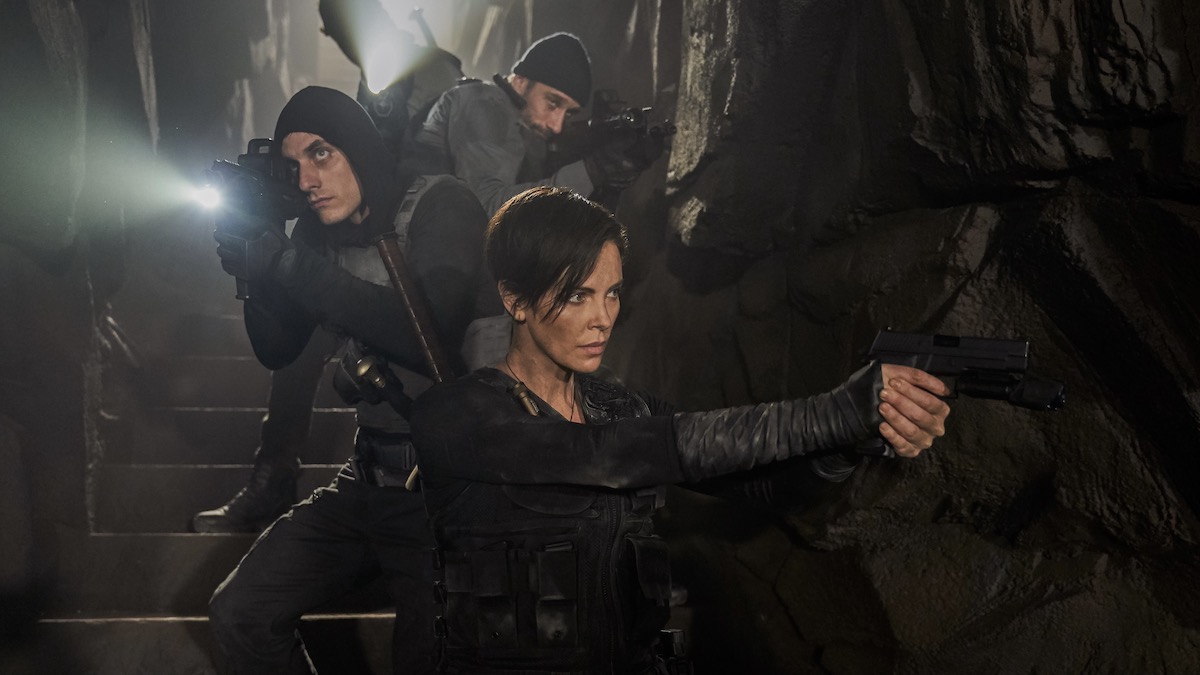 Matthias Schoenaerts, Charlize Theron, dan Luca Marinelli berdiri, bersenjata dan siap di The Old Guard - film fantasi terbaik di netflix