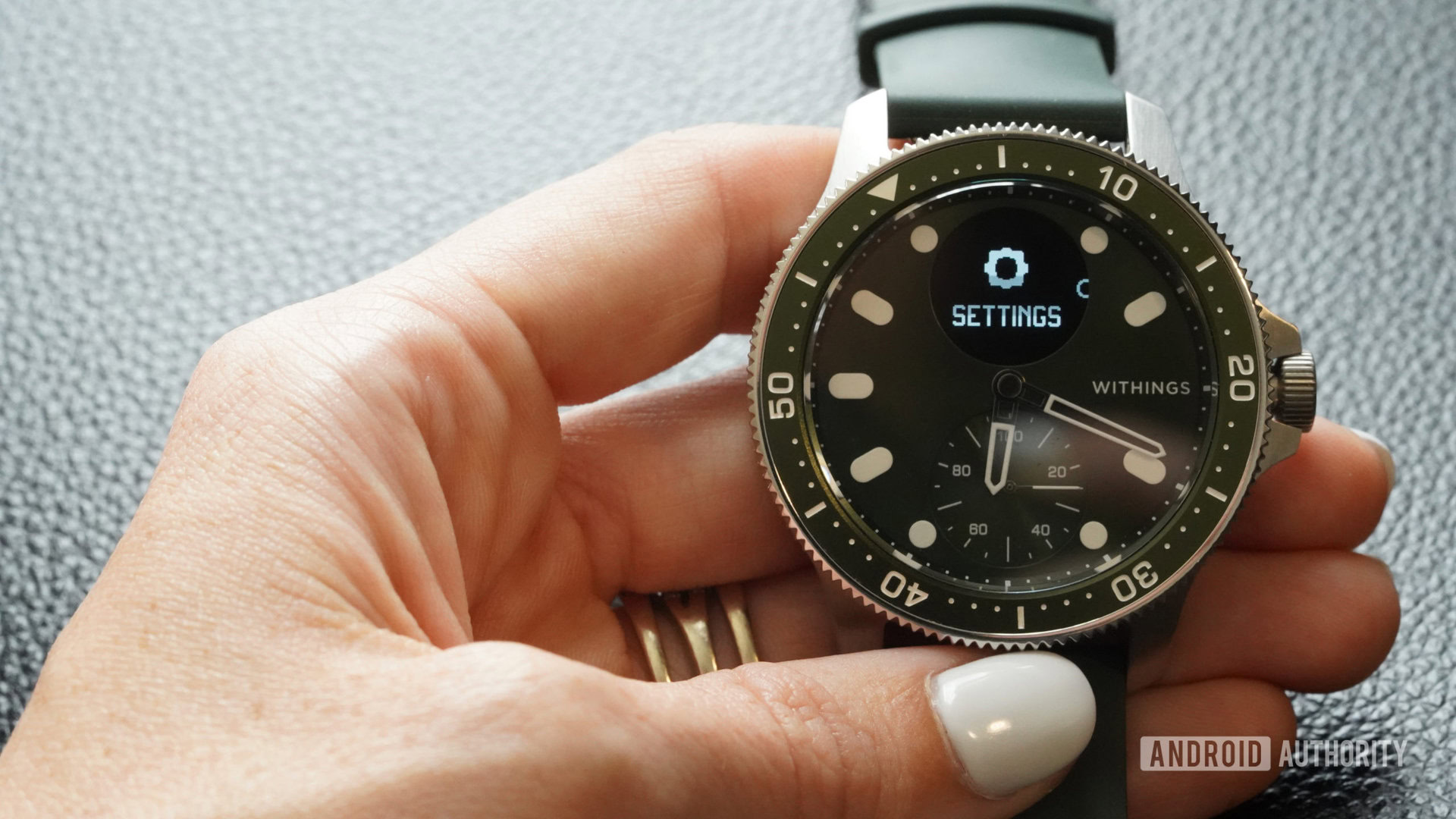 A user holds a Withings ScanWatch Horizon with the Settings icon displayed.