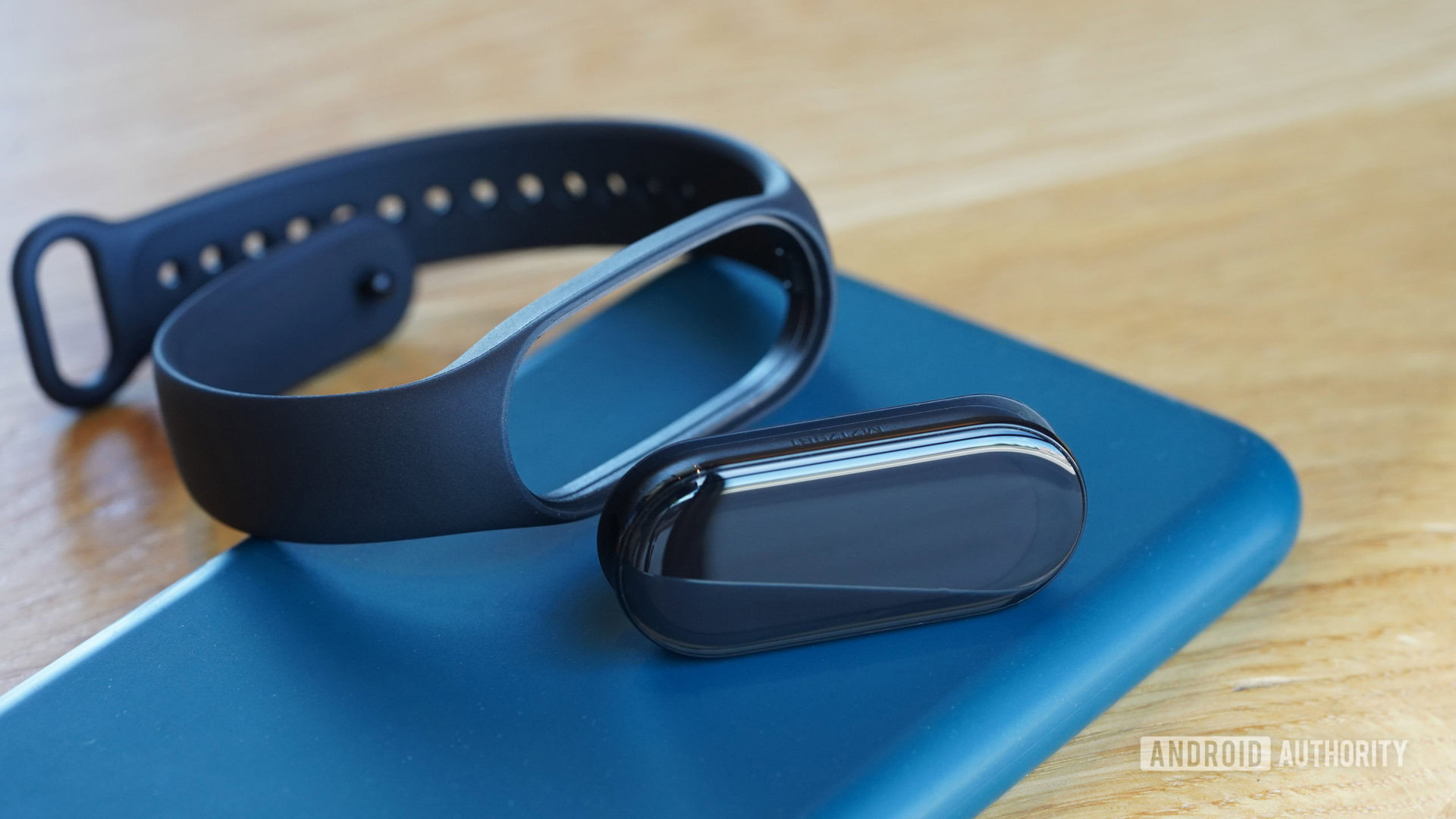 A Xiaomi Mi Band 7 capsule rests alongside its strap.