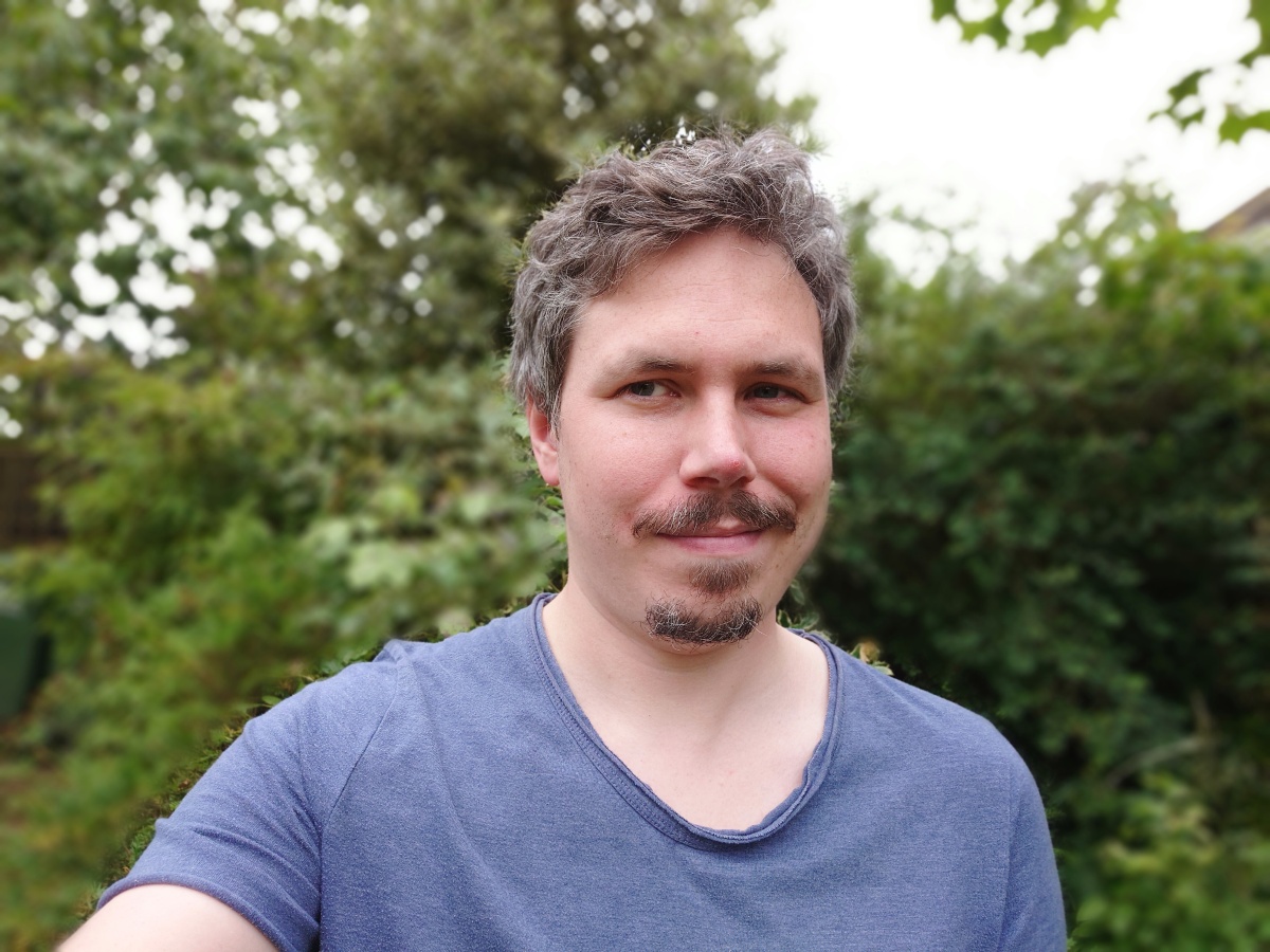 Xperia 1 IV selfie camera sample outdoors of man in blue t-shirt using portrait mode