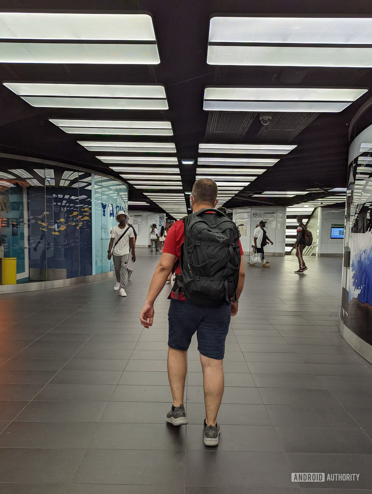 Man walking in train station with the Osprey Farpoint backpack on his back