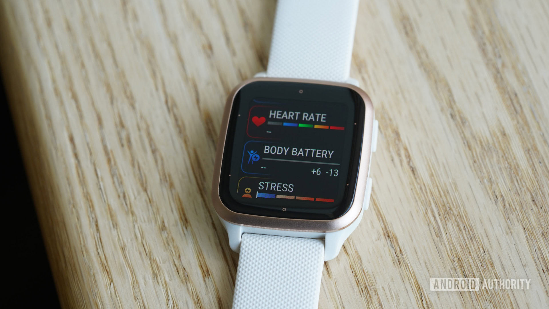 A Garmin Venu Sq 2 rests on a wooden table displaying a user's health stats.