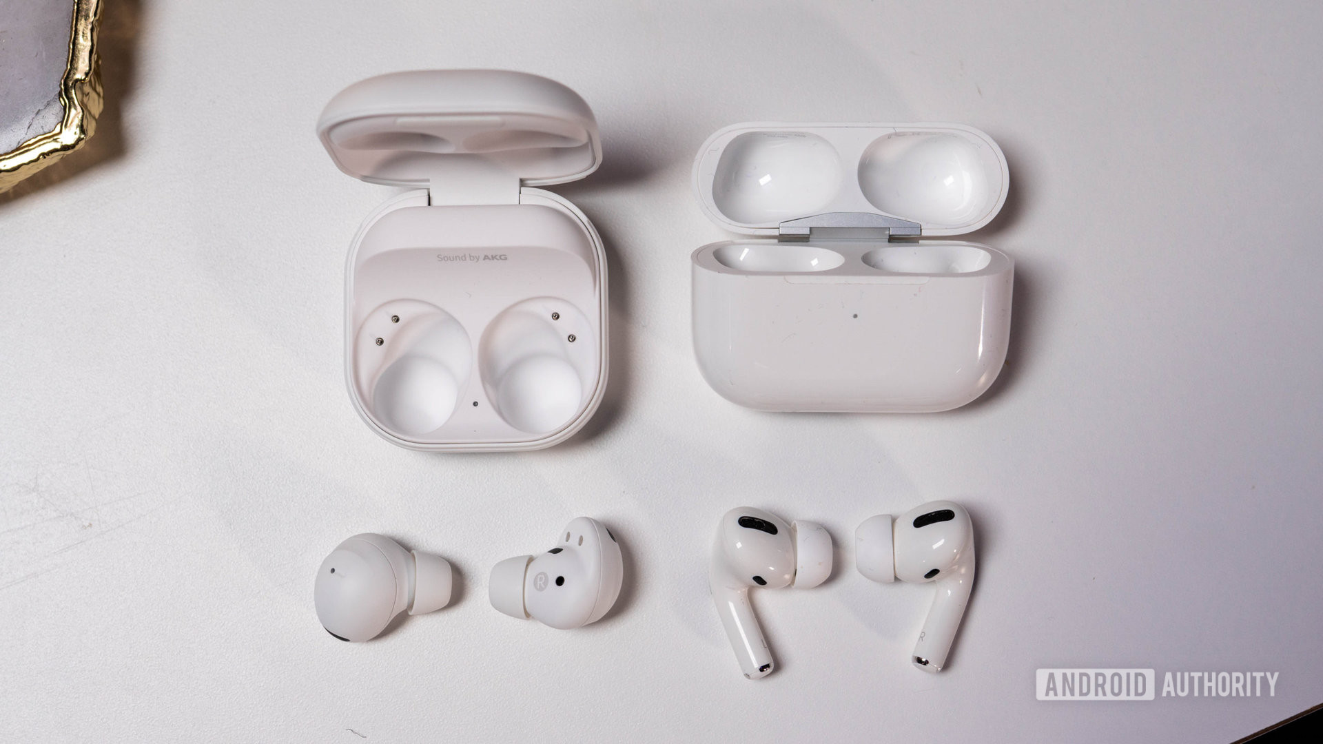 Samsung Galaxy Buds 2 Pro vs AirPods Pro laying next to charging case
