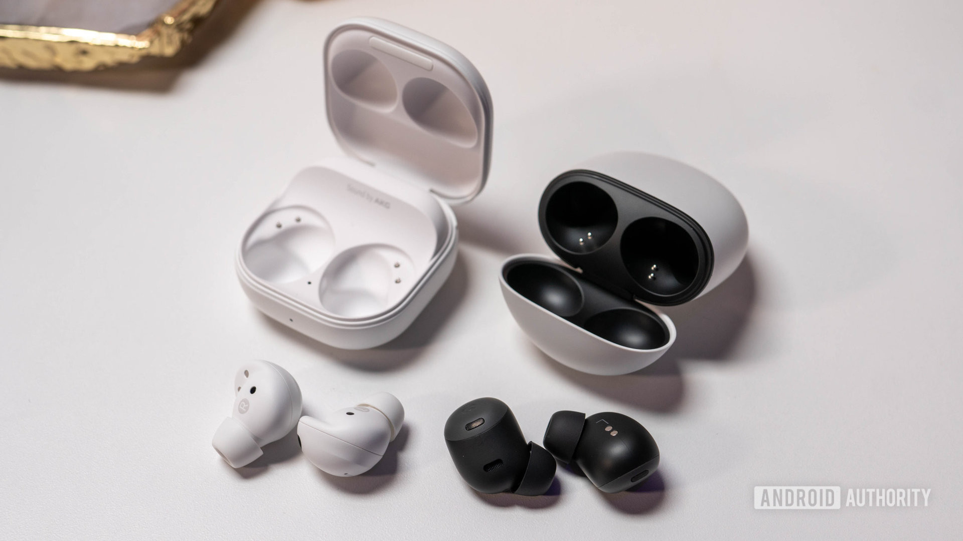 Samsung Galaxy Buds 2 Pro vs Pixel Buds Pro laying next to charging cases