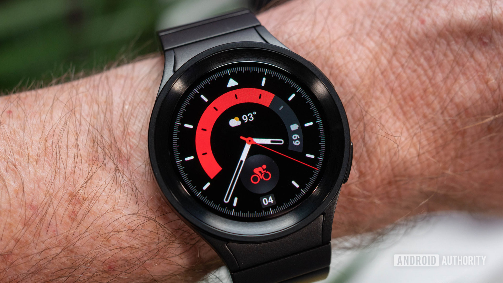 Samsung Galaxy Watch 5 Pro con correa metálica de color titanio negro en la muñeca que muestra la esfera roja del reloj