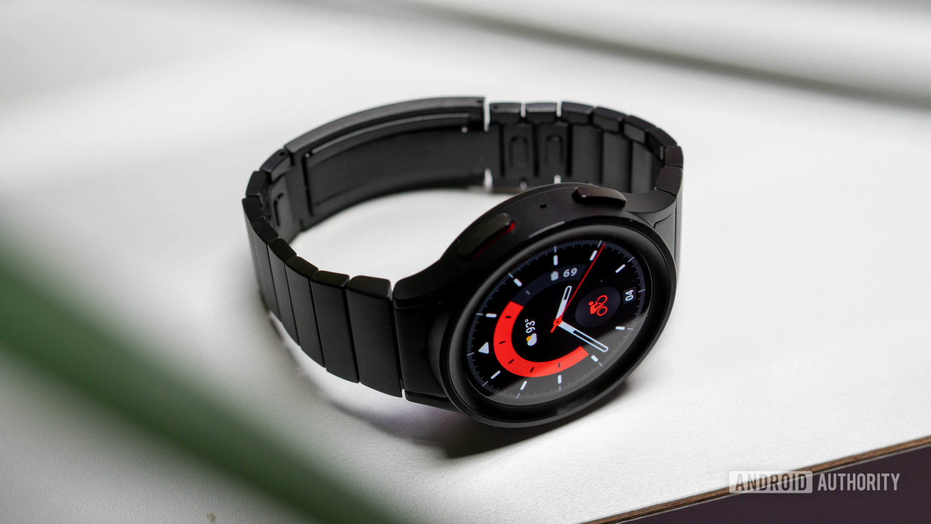 Samsung Galaxy Watch 5 Pro in black titanium color with black metal strap laying on table
