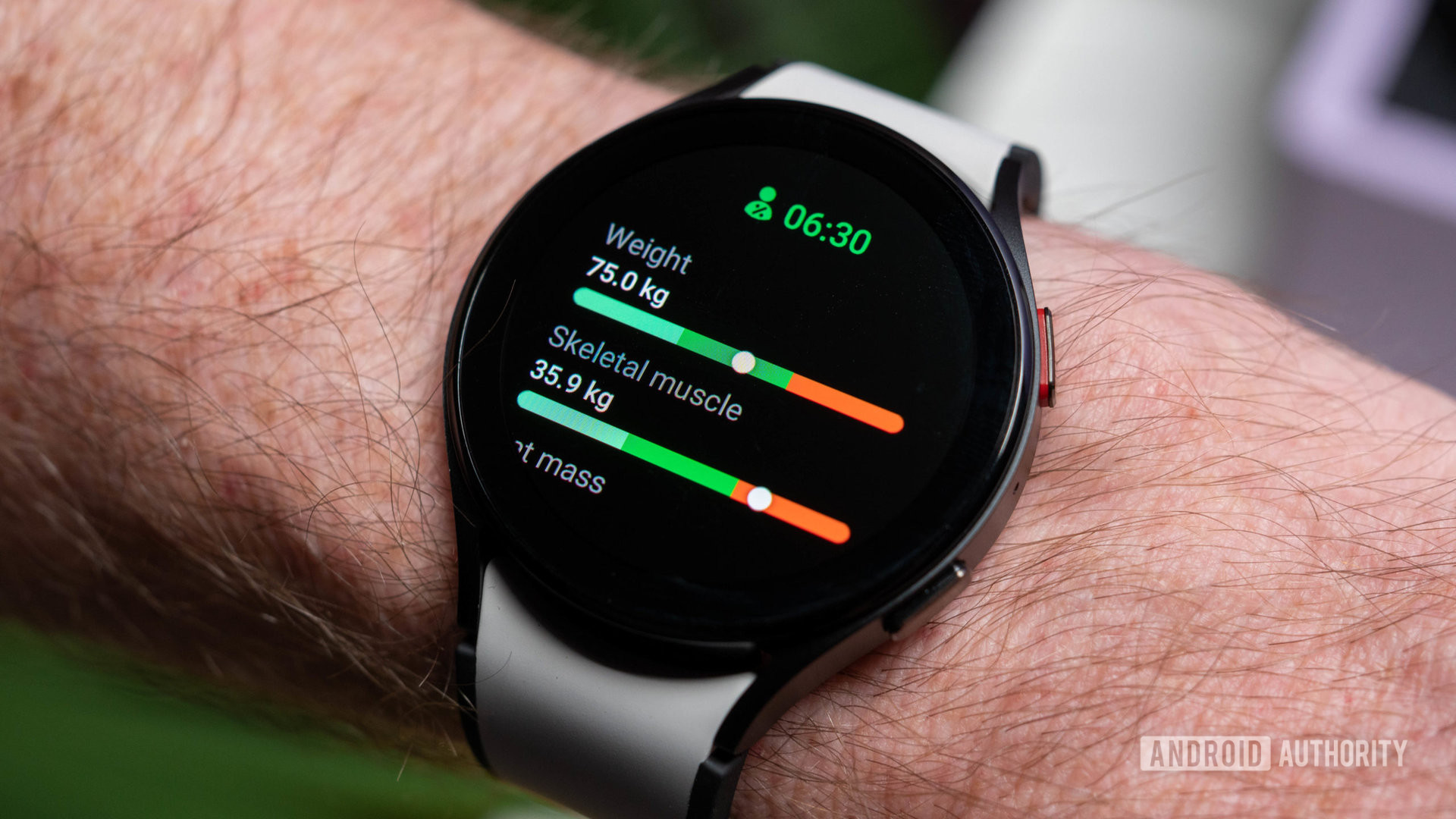 Samsung Galaxy Watch 5 in graphite black color with black and white strap on wrist showing body composition data