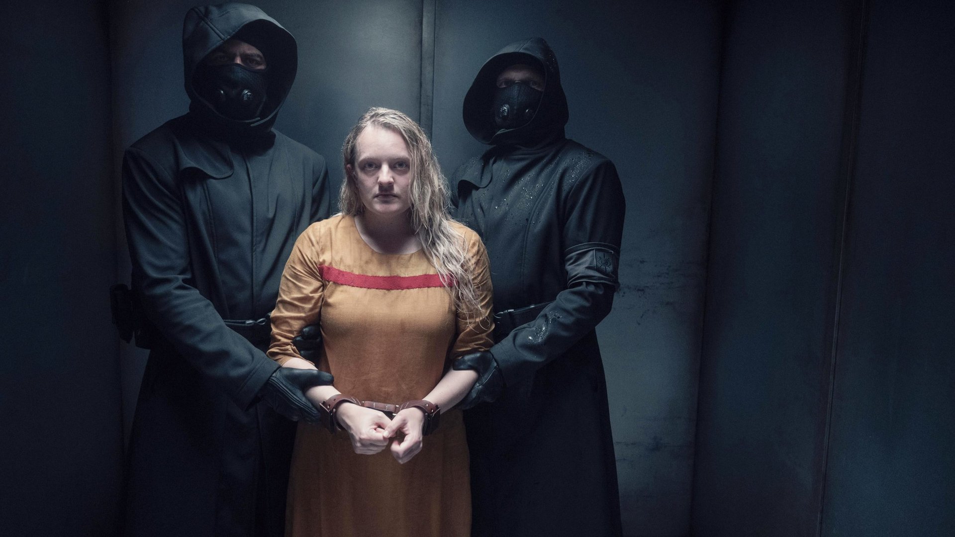 A woman is handcuffed by two masked men in Season 5 of The Handmaids Tale, new to Hulu