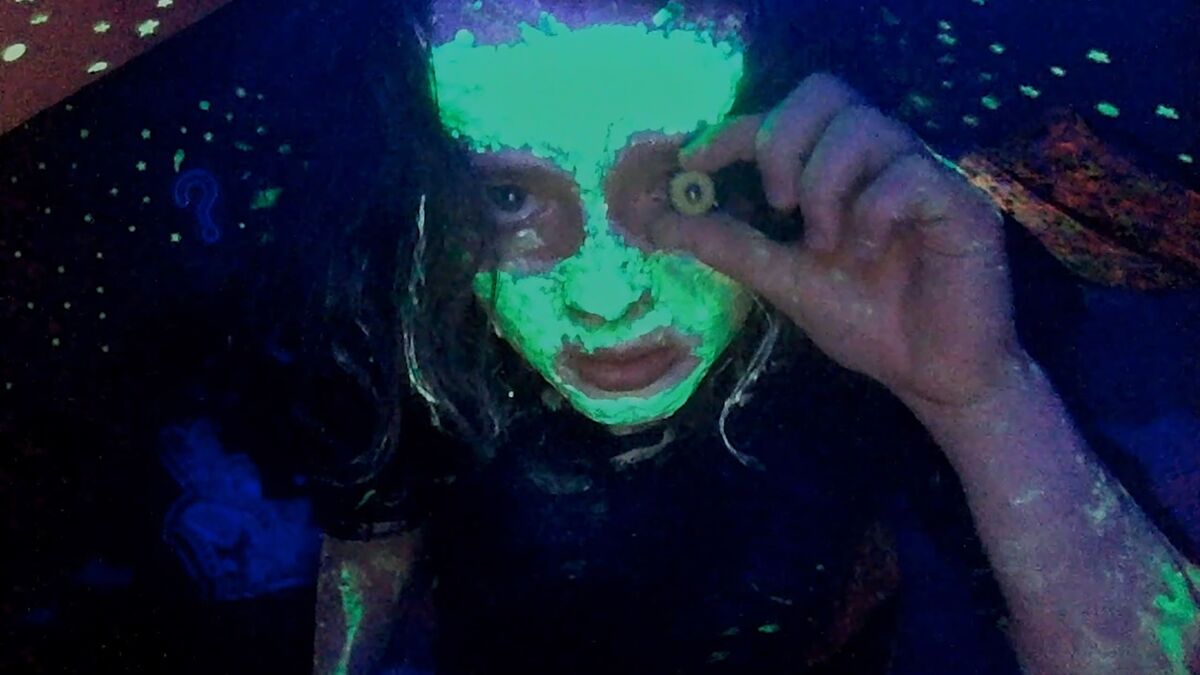 A girl in green black-light makeup in We're All Going To The World's Fair