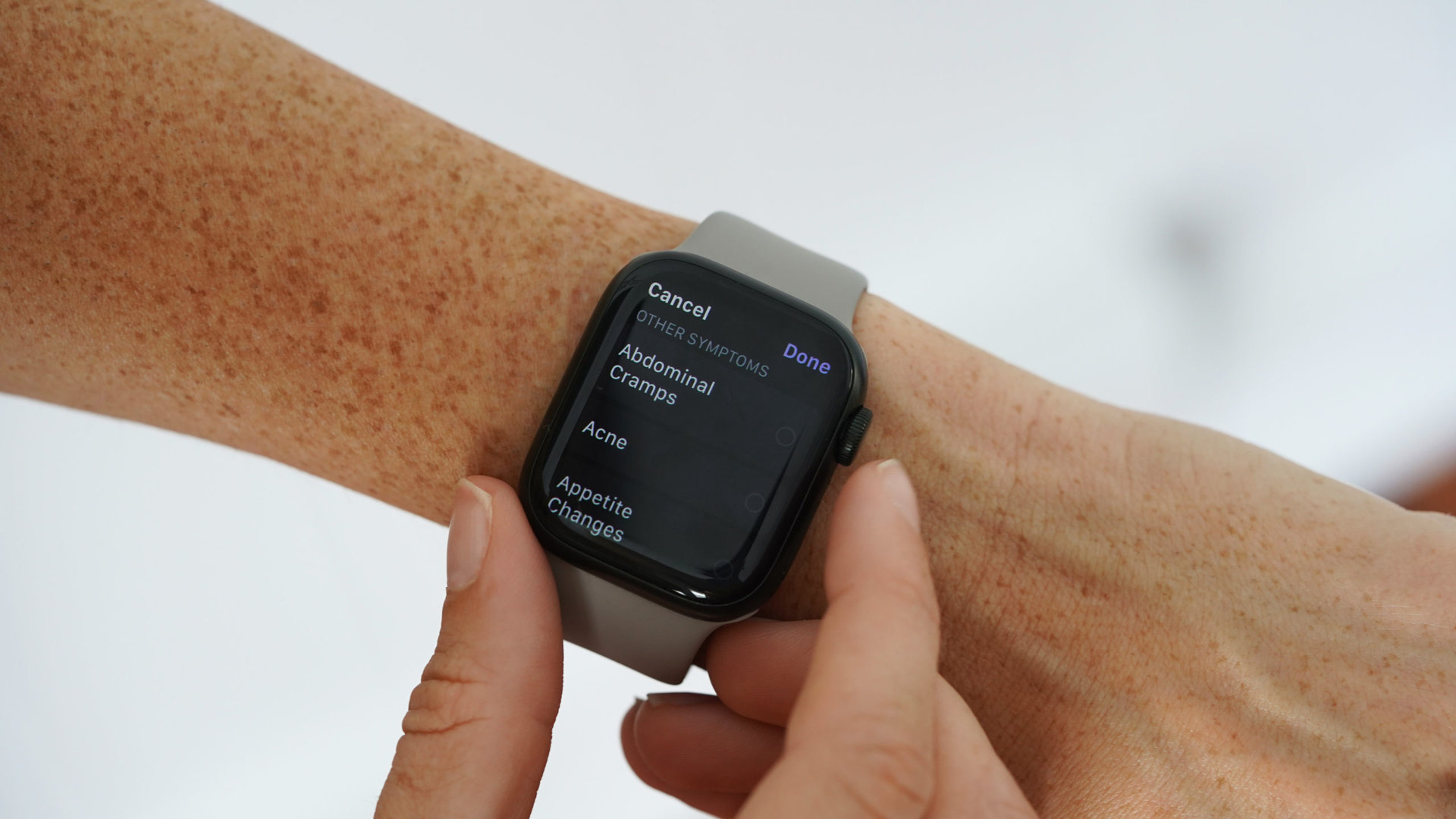 An Apple Watch user adds symptoms in the Cycle Tracking app.