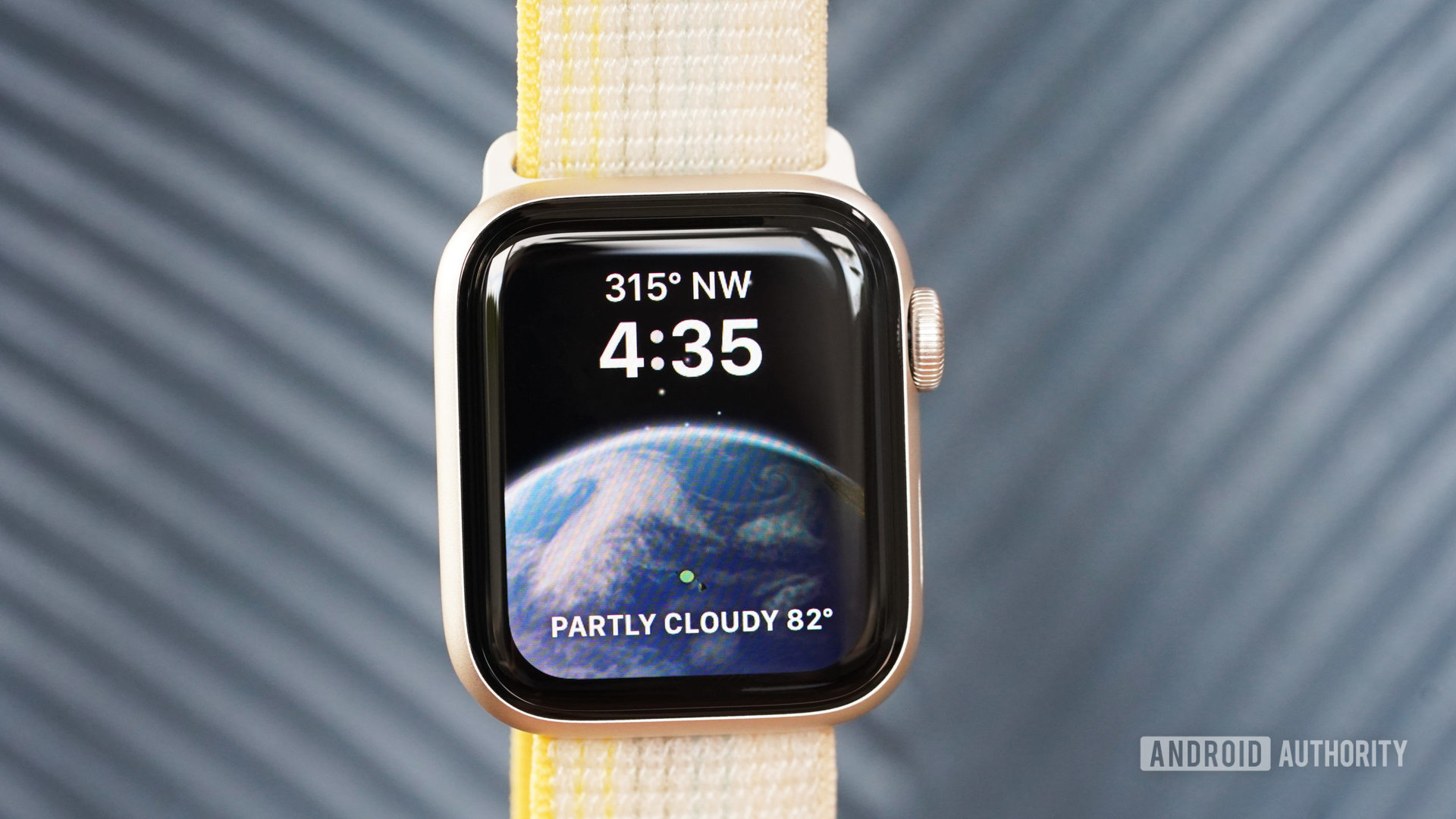 An Apple Watch SE displays the Astronomy watch face featuring compass and weather complications.