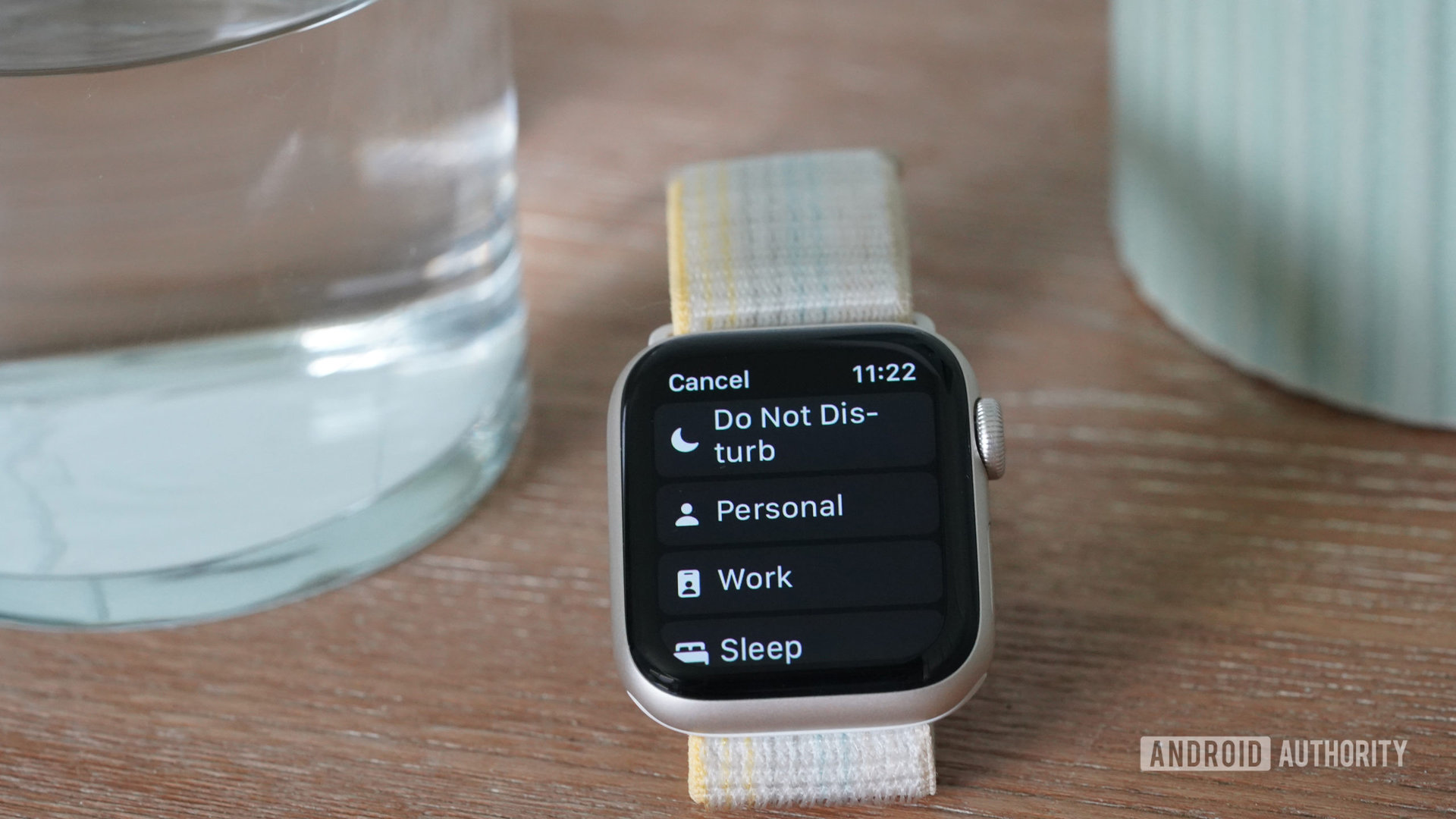 Un Apple Watch SE 2022 descansa junto a un vaso de agua, muestra un menú de configuración de No molestar.