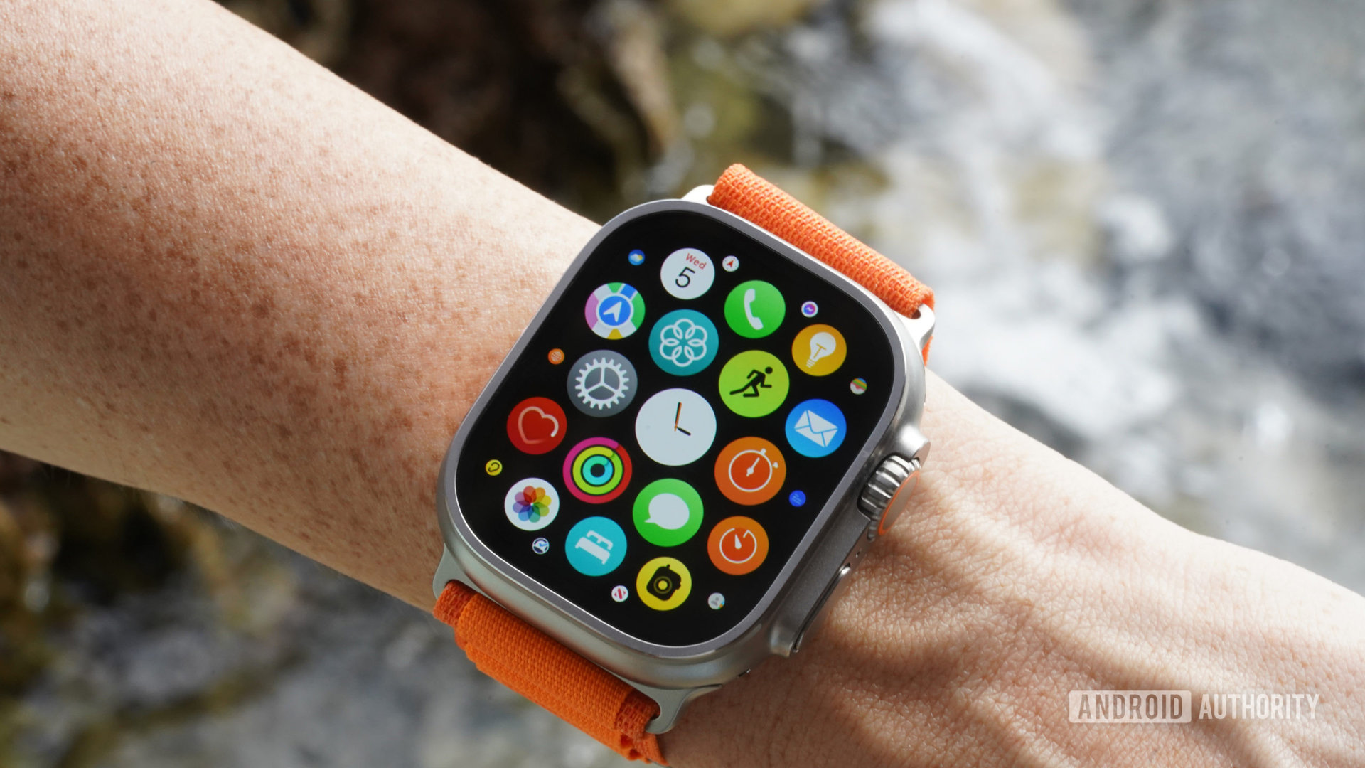 Apple Watch Ultra di pergelangan tangan pengguna menampilkan perpustakaan aplikasi perangkat.
