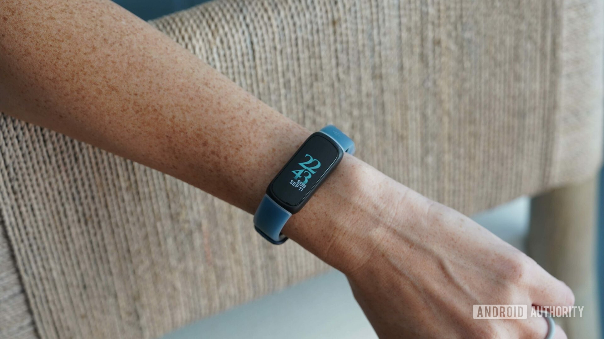 Le Fitbit Inspire 3, avec une bande translucide en Deep Dive, affiche l'heure et la date.