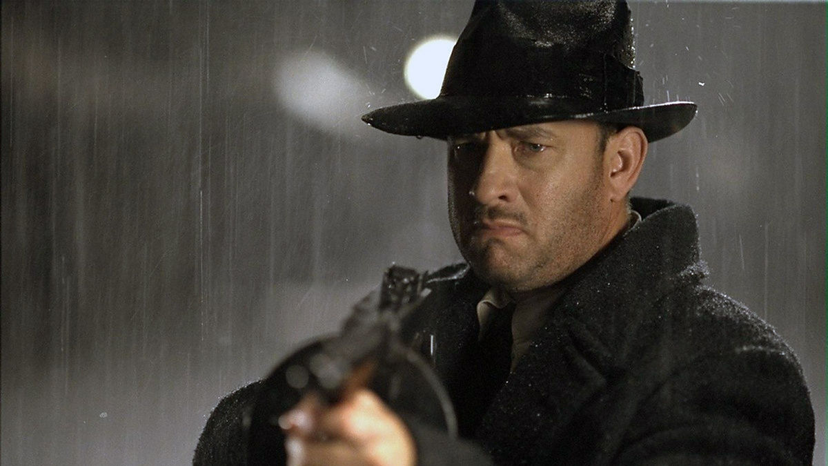 Tom Hanks aims a machine gun in the rain in Road to Perdition - best gangster movies on netflix