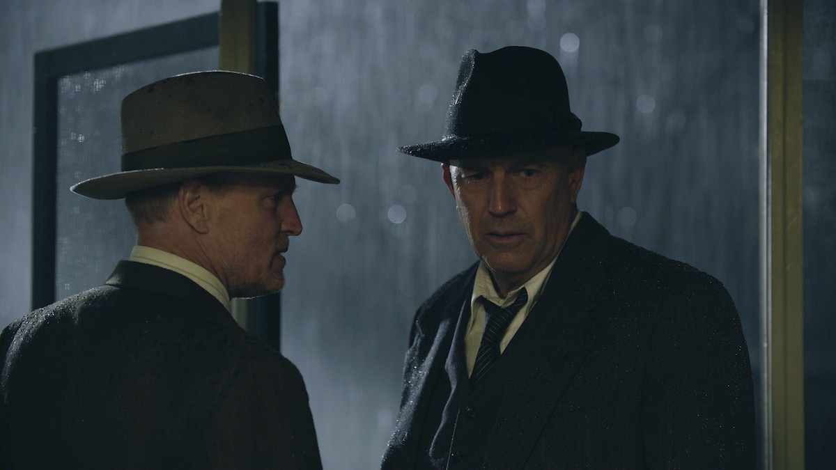 Woody Harrelson (&quot;Many Gault&quot;) and Kevin Costner (&quot;Frank Hamer&quot;) stand together in the rain in The Highwaymen - best gangster movies on Netflix