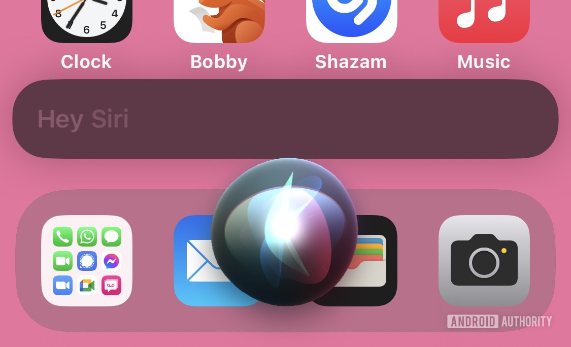 A screenshot of iOS showing the Siri bubble visible on screen and the text &quot;Hey Siri&quot; above it.