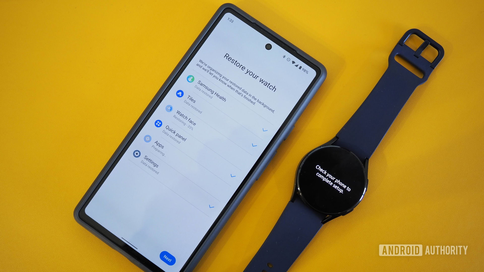 Samsung Galaxy Watch 4 next to Google Pixel 6a with the restore process on the watch